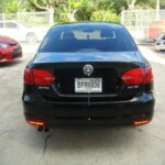 Before and after photographs of a damaged black Volkswagon Jetta that was repaired by Elite Paint & Body Shop in West Palm Beach, Florida.